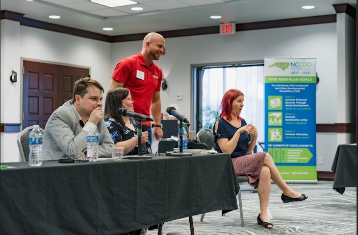 Group of people talking at a meeting.